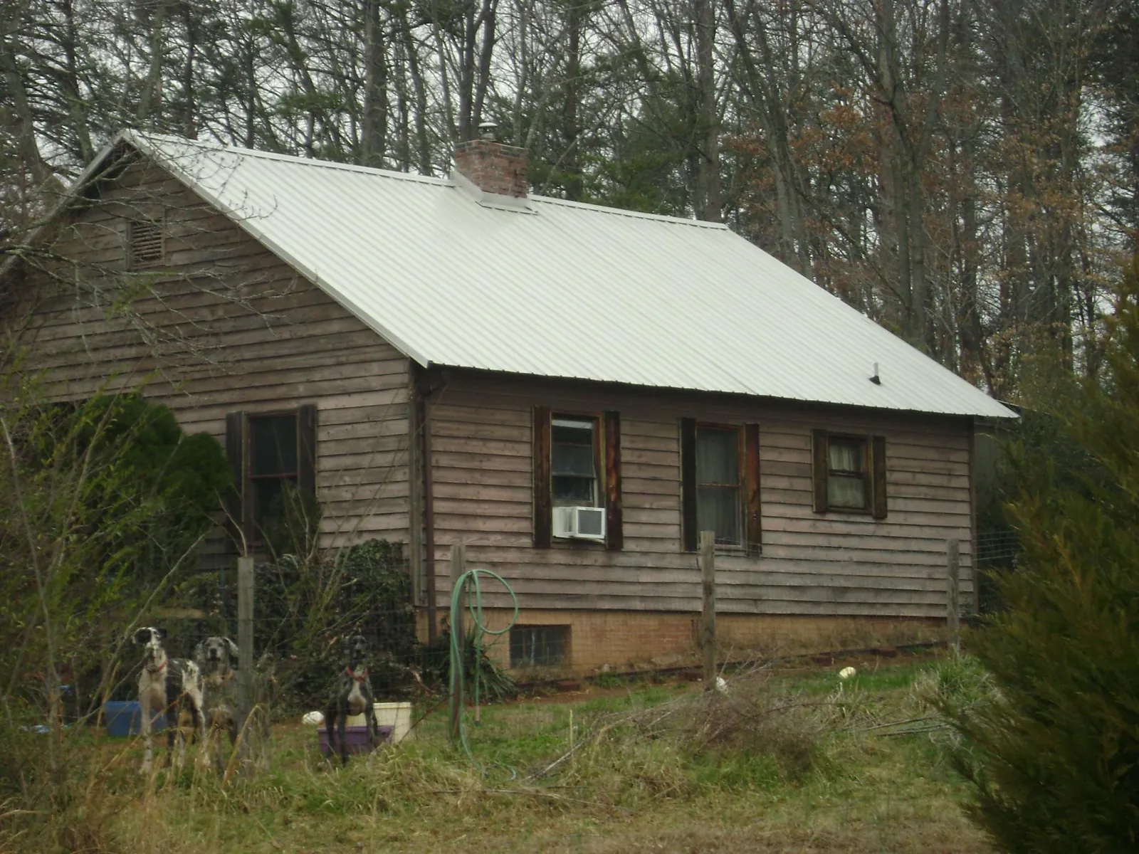 White metal roof on an old wood sided farmhouse, from a Metal Roof Installation job in Bennett